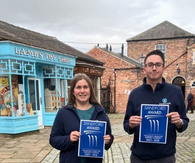 Staff from Preston Park holding up a Sandford award while standing in the Victorian Street.