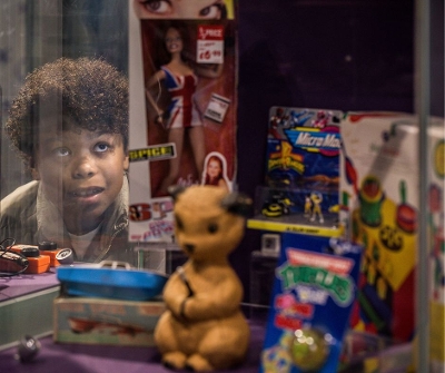 Child looking through glass at popular toys from the 1980s 