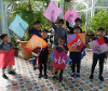 A group of children holding up custom made kites made at the event.