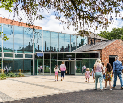 People walking towards the glass museum entrance. 