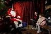 Two children meeting Father Christmas in his traditional grotto on the Victorian Street