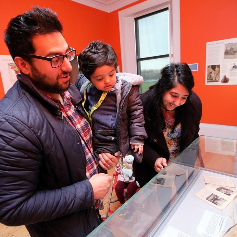 Family Looking At Items On Display In Preston Park's Gallery Family Looking At Items In Preston Park